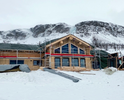 Bilde av stavlaft hytte under oppføring av Geilo Laft AS i vinter fjell